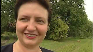 Lovely mature lady blows a guy's cock outdoors near the car