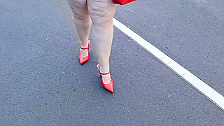 Beautiful woman walking outdoors in public parking lot showing off for strangers