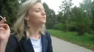 Blonde beauty smoking a cigarette outdoors