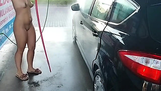 naked woman washes a car at a car wash