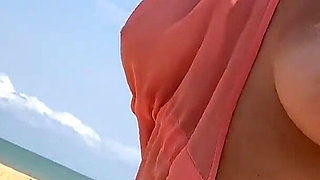 A Busty Blonde Woman Is Walking Around and Showing Her Naked Body on the Beach.